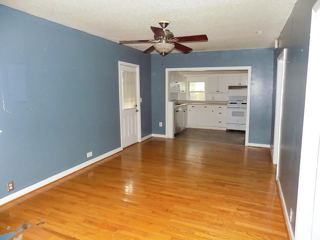 unfurnished living room with light hardwood / wood-style floors, a textured ceiling, and ceiling fan