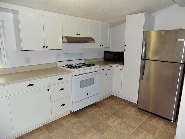 kitchen featuring white gas stove, stainless steel fridge, white cabinetry, and a textured ceiling