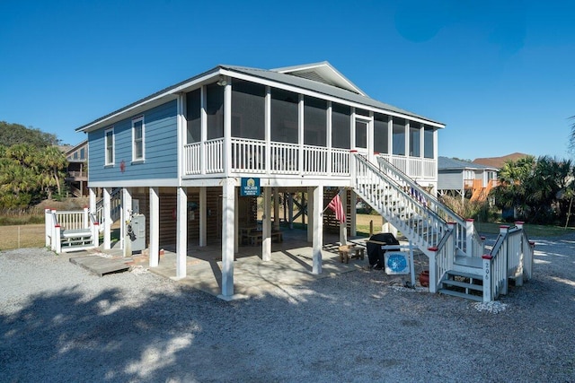 back of property featuring a carport and a sunroom