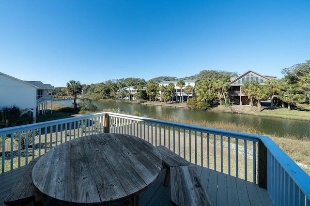 wooden deck featuring a water view and a grill