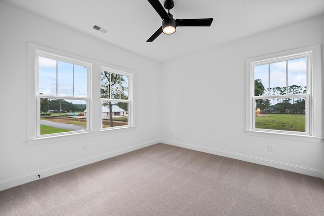 unfurnished room featuring ceiling fan, a wealth of natural light, and carpet floors