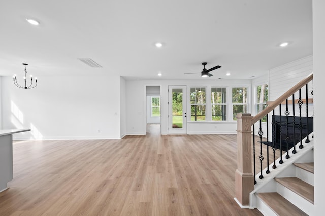 unfurnished living room featuring light hardwood / wood-style floors and ceiling fan with notable chandelier