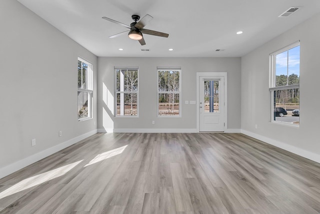 unfurnished living room featuring ceiling fan, plenty of natural light, and light wood-type flooring