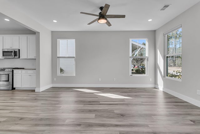 unfurnished living room with ceiling fan and light hardwood / wood-style flooring