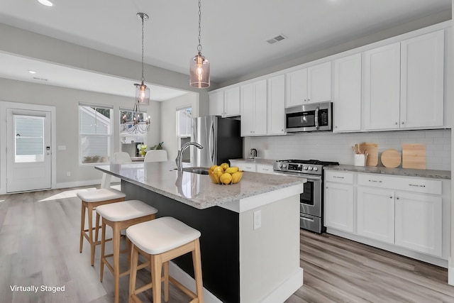 kitchen featuring light wood-style floors, appliances with stainless steel finishes, and backsplash