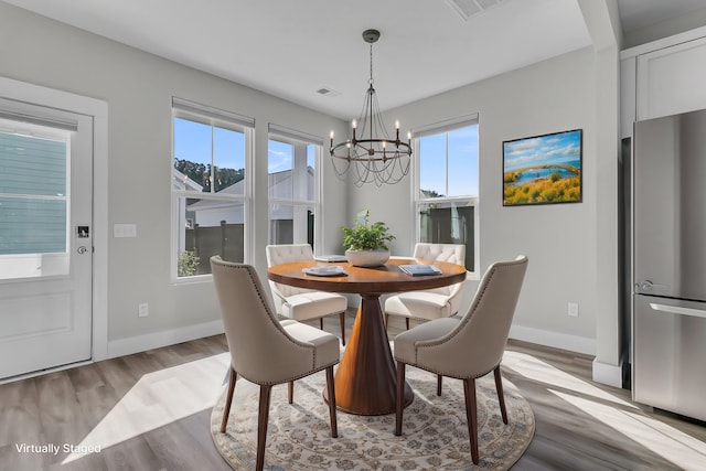 dining area with an inviting chandelier and light wood-type flooring