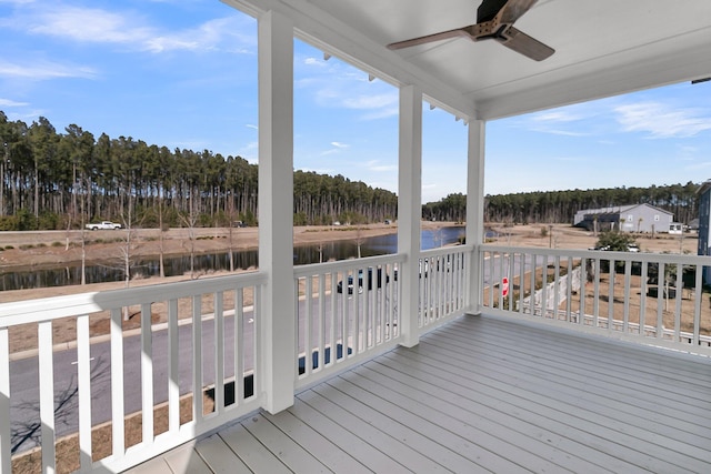 deck with a water view and ceiling fan