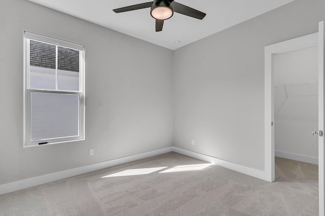 carpeted empty room featuring ceiling fan and baseboards