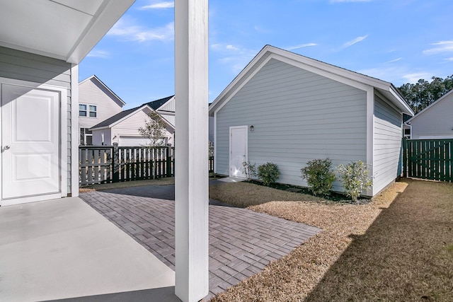 view of patio with an outbuilding and fence