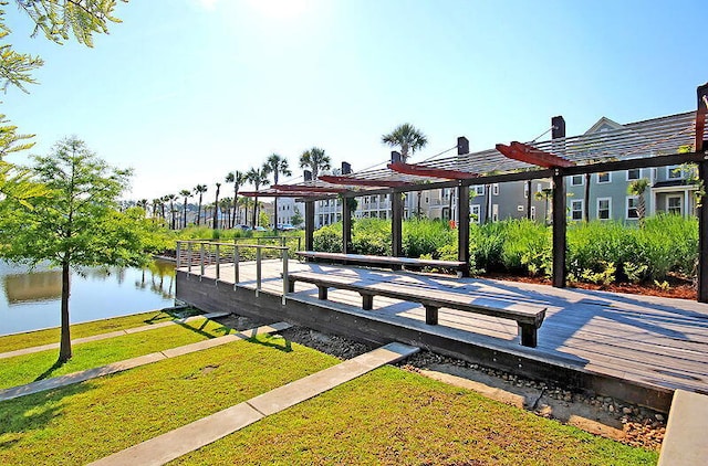 dock area with a water view, a pergola, and a lawn