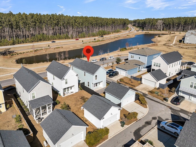 bird's eye view featuring a water view, a wooded view, and a residential view