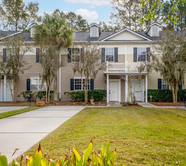 view of front of property featuring a balcony and a front lawn