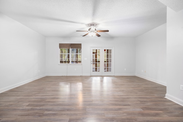 spare room featuring ceiling fan, dark hardwood / wood-style flooring, a textured ceiling, and french doors