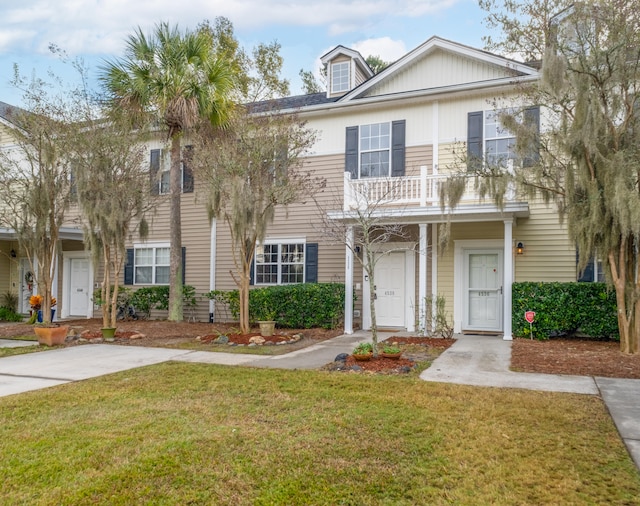 view of front of house featuring a balcony and a front yard