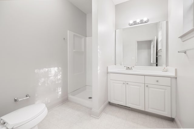 bathroom featuring vanity, toilet, and a shower