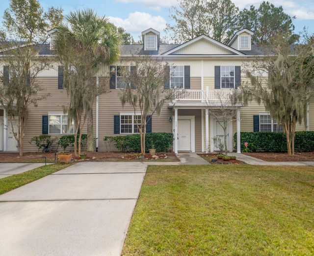 view of front of house featuring a front yard and a balcony