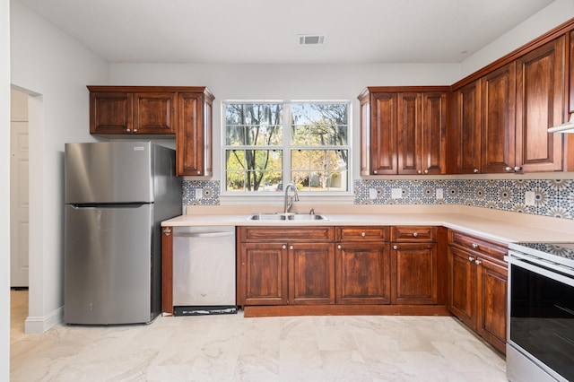 kitchen with sink, appliances with stainless steel finishes, and tasteful backsplash