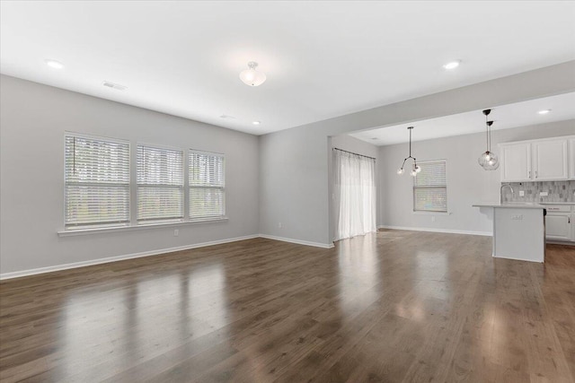 525 Purple Finch Rd, Summerville, SC 29486 - unfurnished living room with dark wood-style flooring, baseboards, recessed lighting, and a sink