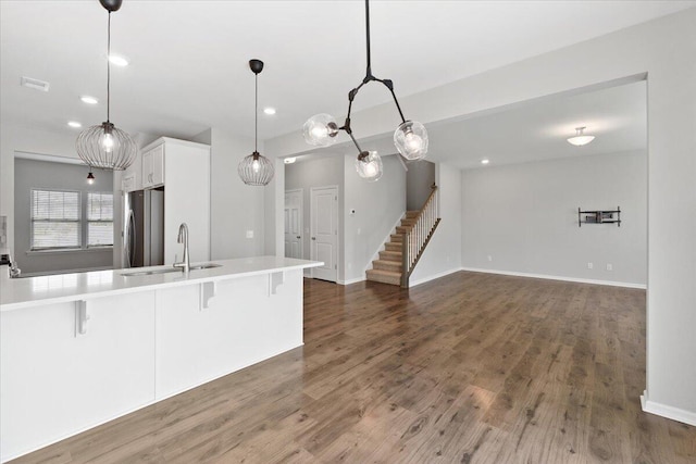 525 Purple Finch Rd, Summerville, SC 29486 - kitchen with freestanding refrigerator, a sink, a kitchen bar, white cabinets, and recessed lighting