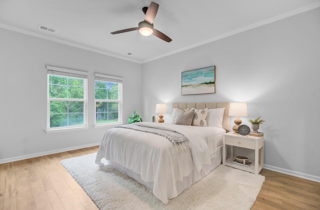 bedroom with crown molding, baseboards, light wood-type flooring, and ceiling fan