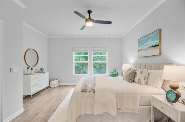 bedroom featuring wood finished floors, crown molding, baseboards, and a ceiling fan