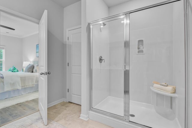 ensuite bathroom with a shower stall, baseboards, and ornamental molding