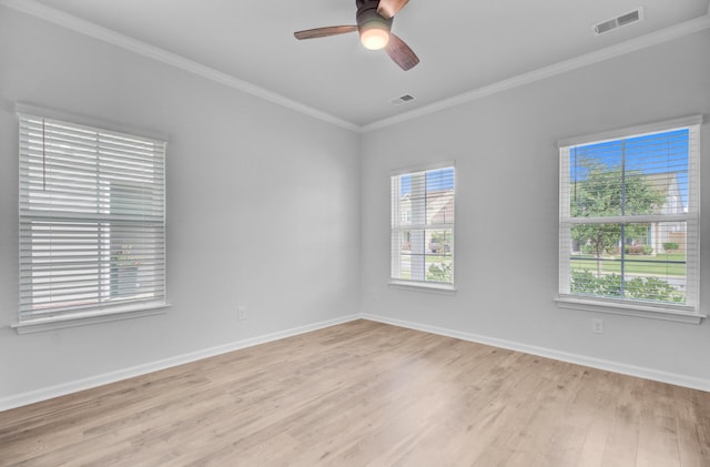 spare room featuring light wood-type flooring, ornamental molding, ceiling fan, and baseboards