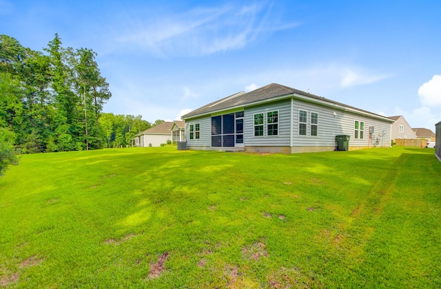 rear view of property featuring a lawn and a sunroom
