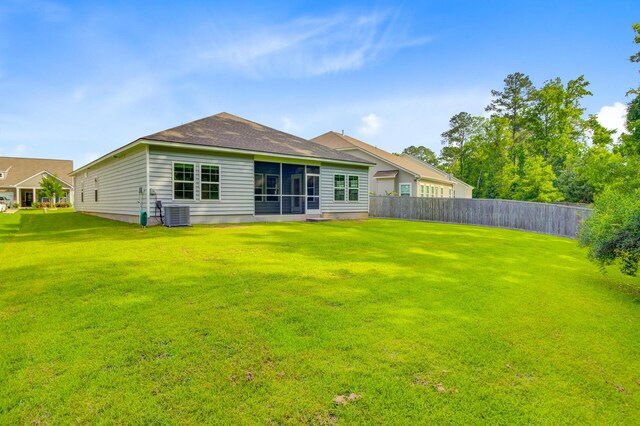 rear view of house featuring a sunroom and central AC
