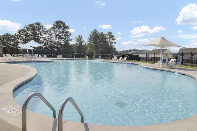 community pool with fence and a patio