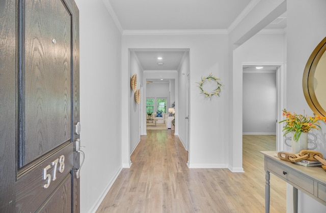 foyer featuring light wood-type flooring, baseboards, and crown molding