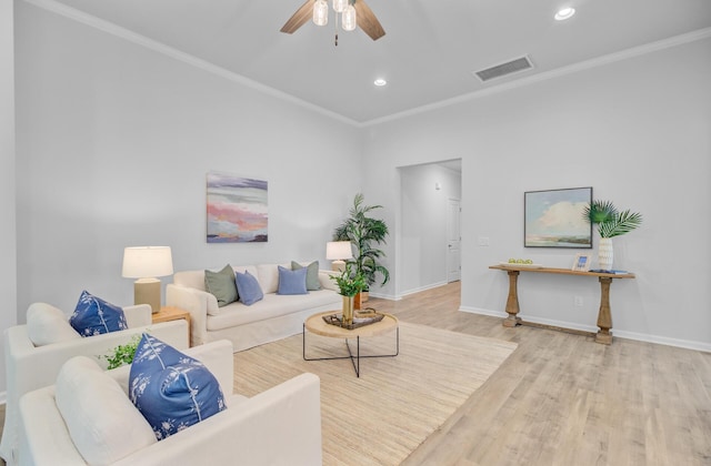living area featuring wood finished floors, ornamental molding, recessed lighting, a ceiling fan, and baseboards
