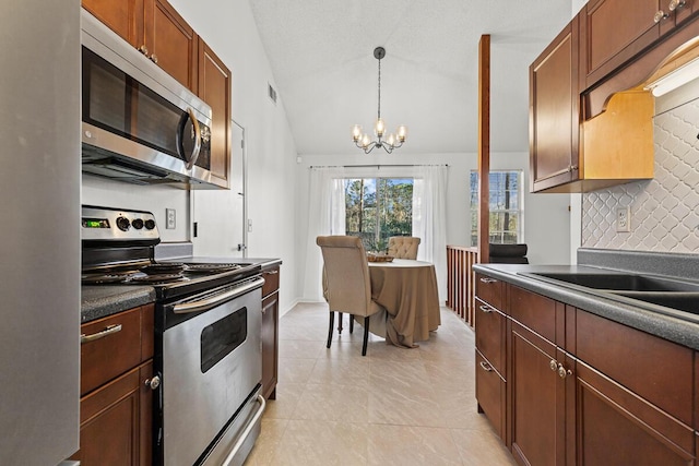 kitchen featuring stainless steel appliances, tasteful backsplash, visible vents, vaulted ceiling, and a chandelier