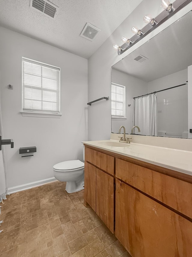 full bath with toilet, vanity, and visible vents