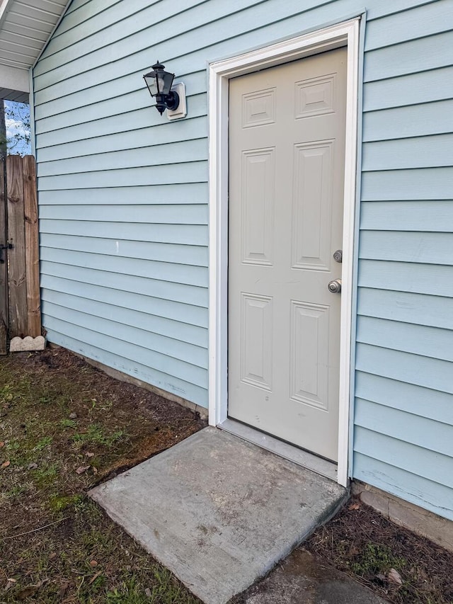 view of exterior entry featuring fence