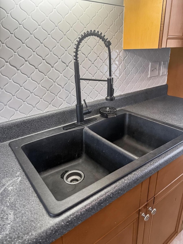 interior details with dark countertops, brown cabinets, and a sink