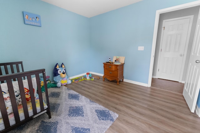 bedroom with baseboards and wood finished floors