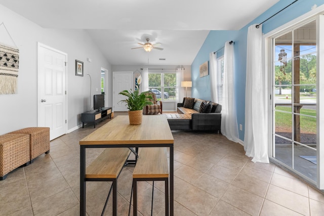 living area featuring light tile patterned floors, a ceiling fan, vaulted ceiling, and baseboards