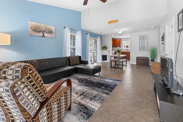 living room with tile patterned floors, ceiling fan, and a fireplace