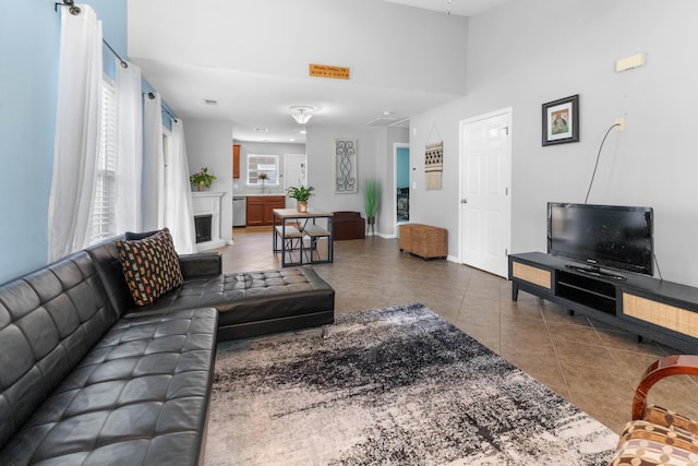 living area with tile patterned floors, baseboards, and a fireplace with raised hearth