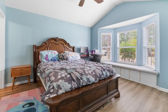 bedroom with light wood-type flooring, multiple windows, lofted ceiling, baseboards, and ceiling fan