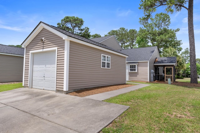 view of side of home featuring a shingled roof, a lawn, driveway, and a garage