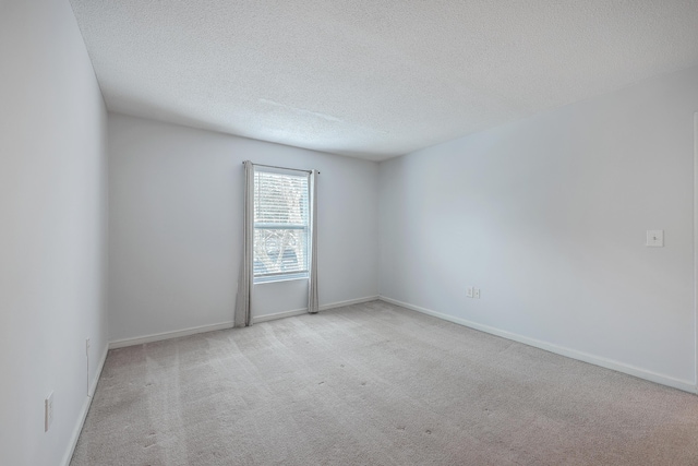 carpeted spare room with a textured ceiling