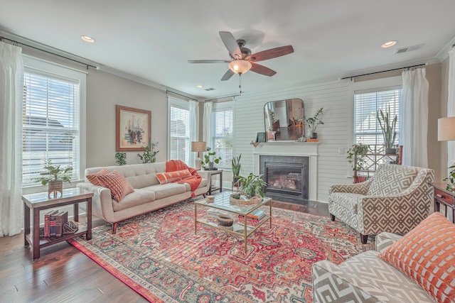 living room with hardwood / wood-style flooring, crown molding, and ceiling fan