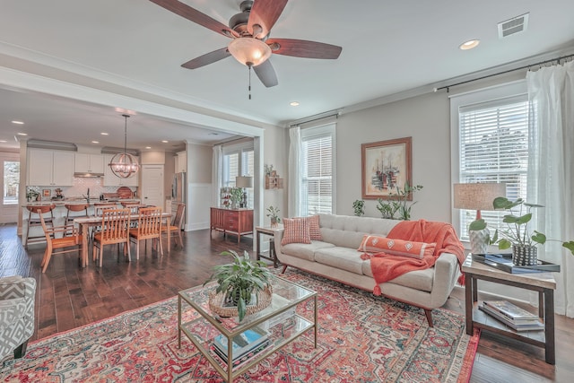 living room featuring ceiling fan, dark hardwood / wood-style flooring, sink, and crown molding