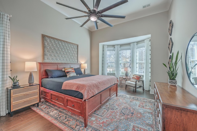 bedroom with ceiling fan, wood-type flooring, and multiple windows