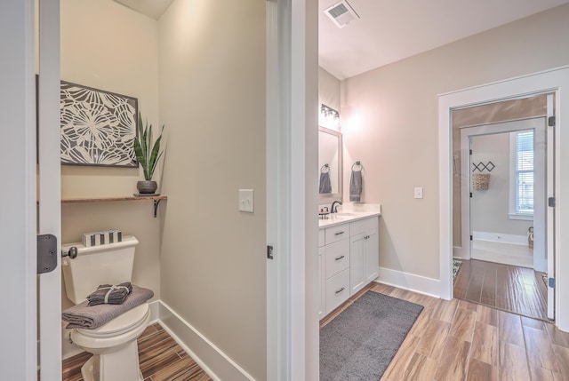 bathroom featuring toilet, hardwood / wood-style flooring, and vanity