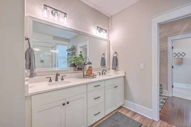 bathroom featuring a shower with shower door and vanity