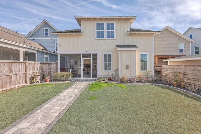 rear view of property featuring a sunroom and a yard