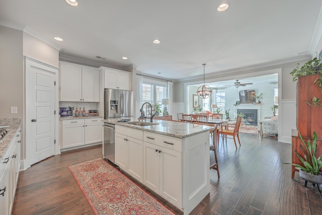 kitchen featuring decorative light fixtures, sink, white cabinets, and stainless steel appliances